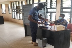 A security personnel going through the voting process