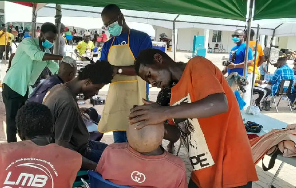 Some members of the public receiving a haircut