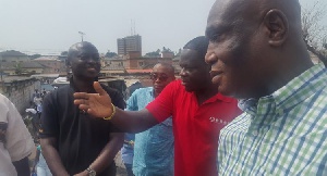 Samuel Atta Akyea (first left) listening to a resident at Adabraka