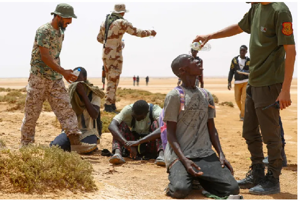 Libyan border guards provide water to Africans who say they were abandoned by Tunisian authorities