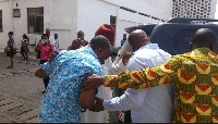 Obengfo in blue attire being assisted to the car