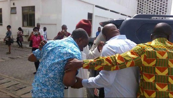 Obengfo in blue attire being assisted to the car