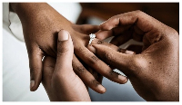 File photo of a groom putting a ring on his bride's finger