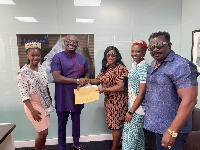 CEO of Empire Media Bola Ray (second left) exchanges papers with co-organizers