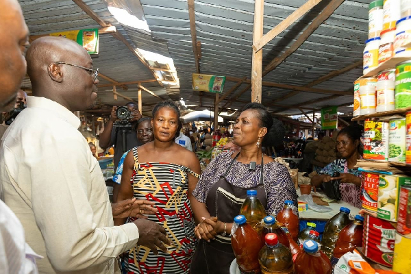 Ato Forson (L) engaging traders at the market