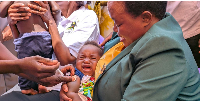 Prime Minister Robinah Nabbanja holds a baby at the launch of the malaria vaccination exercise