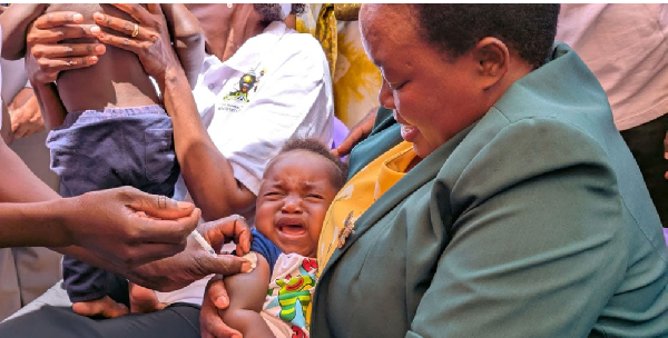 Prime Minister Robinah Nabbanja holds a baby at the launch of the malaria vaccination exercise