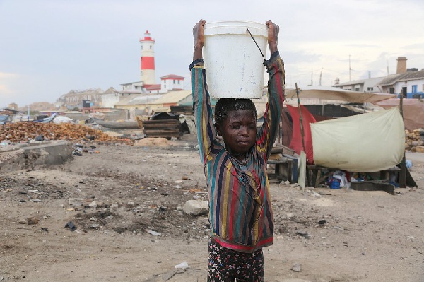 A child carries water from the shore of Jamestown in Accra