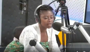 Elis Koina with her baby strapped to her back as she delivered the song renditions in studio