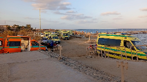 Rescuers and ambulance cars wait on the beach for possible survivors