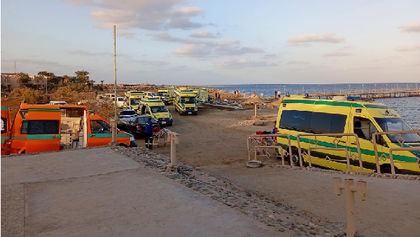 Rescuers and ambulance cars wait on the beach for possible survivors