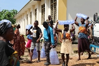 People carrying bags of water