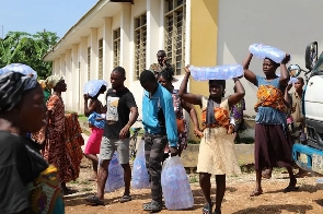 People carrying bags of water