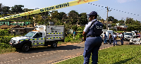 A police officer is seen at a scene of a mass shooting at a house party in KwaMakhutha township