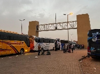 Buses line up at the Egyptian-Sudanese border as thousands of refugees wait to cross