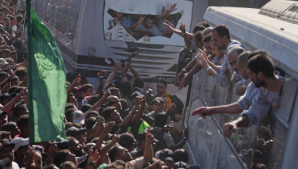 People gather to greet freed Palestinian prisoners arriving on buses in the Gaza Strip