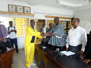 Captain of the Golden Arms team presents the trophy to Sports Minister