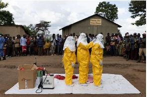 Red Cross workers don PPE prior to burying a three-year-old boy suspected of dying from Ebola