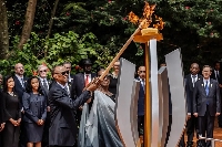 President of Rwanda Paul Kagame (centre) and the first lady light a remembrance flame
