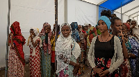 Tigray women who fled the conflict in the Tigray region, stand in line to register their names