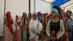 Tigray women who fled the conflict in the Tigray region, stand in line to register their names