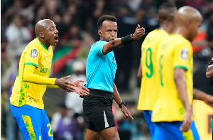 Referee Omar Artan, center, signals a penalty during the CAF Champions League final
