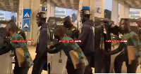 Screenshot of video of artiste being led out of airport