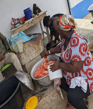 Naa Afrowa coating the pork with some pepper after taking it out of the salt solution