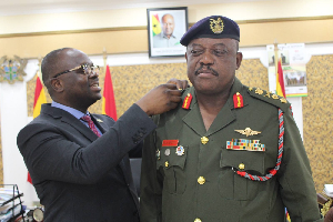Lieutenant General William Agyapong being dressed by Dr Edward Omane Boamah