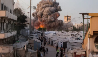Palestinians run for cover as smoke and fire rise during an Israeli strike on the Al-Muttaqin Mosque