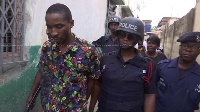 The suspect being escorted by Police personnel