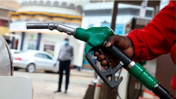 A fuel attendant holding a fuel pump at the filling station