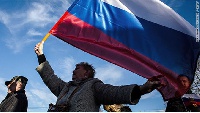 A woman holding the flag of Russia