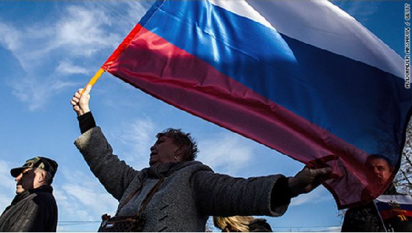 A woman holding the flag of Russia