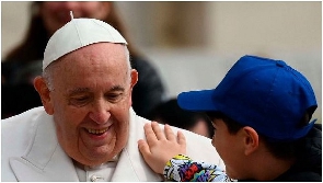 A boy pats Pope Francis on the shoulder on March 29, 2023