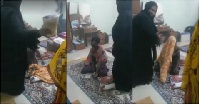 Two Burqa-clad women practicing exorcism on a Ghanaian woman (A picture from the video)