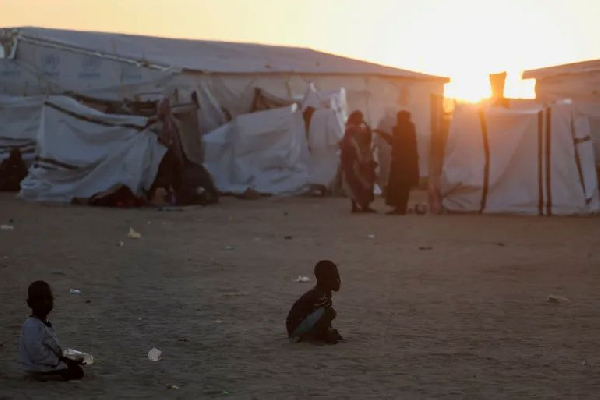 Sudanese refugee children from el-Fasher play as the sun sets over the Tine transit refugee camp