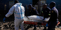 Police officers carry the body of a person on a stretcher after a mass shooting at an