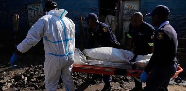 Police officers carry the body of a person on a stretcher after a mass shooting at an