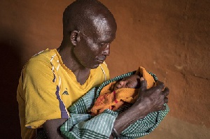 A proud father holds his baby for the first time