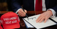 Trump is seen here signing some new tariffs into operation