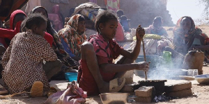 A girl prepares food at a displacement camp in El Fasher, North Darfur region, Sudan on July 9, 2025