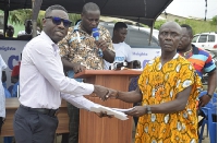 A fisherman receiving his share of the Challenging Heights financial support