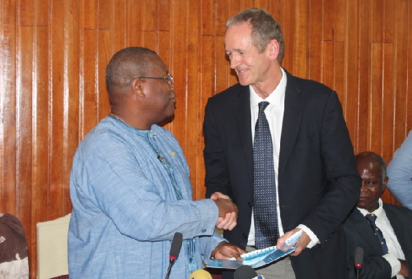 Alex Segbefia, exchanging agreements with Mr Markus Gemuend, Head of Africa, Roche