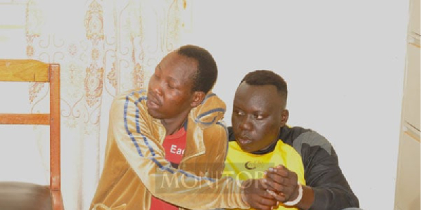 The two suspects handcuffed after their deportation to Uganda from DRC