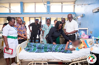 Obuobia Darko-Opoku (wearing black) sharing encouraging messages with a patient