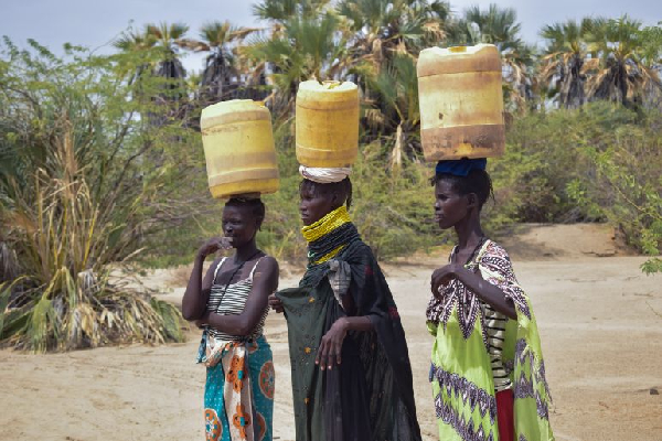 Veronica Akalapatan (far left) and her neighbours pause during their journey to fetch water in Kenya