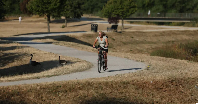A person cycles through parched parkland in Birmingham, Britain, on August 13, 2026