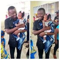 Jefferson Kwamena Sackey with a baby during one of his community engagements