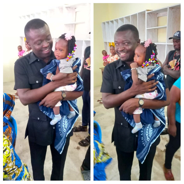 Jefferson Kwamena Sackey with a baby during one of his community engagements